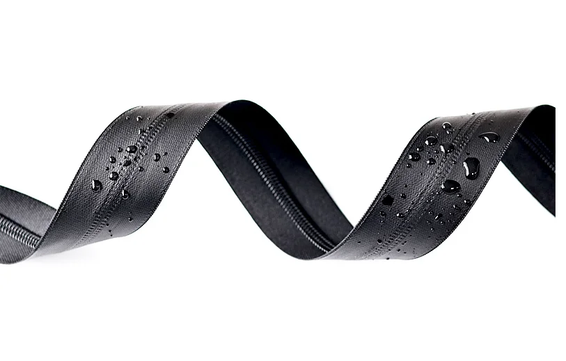 Close-up of a black waterproof zipper with small water droplets indicating its resistance to moisture.