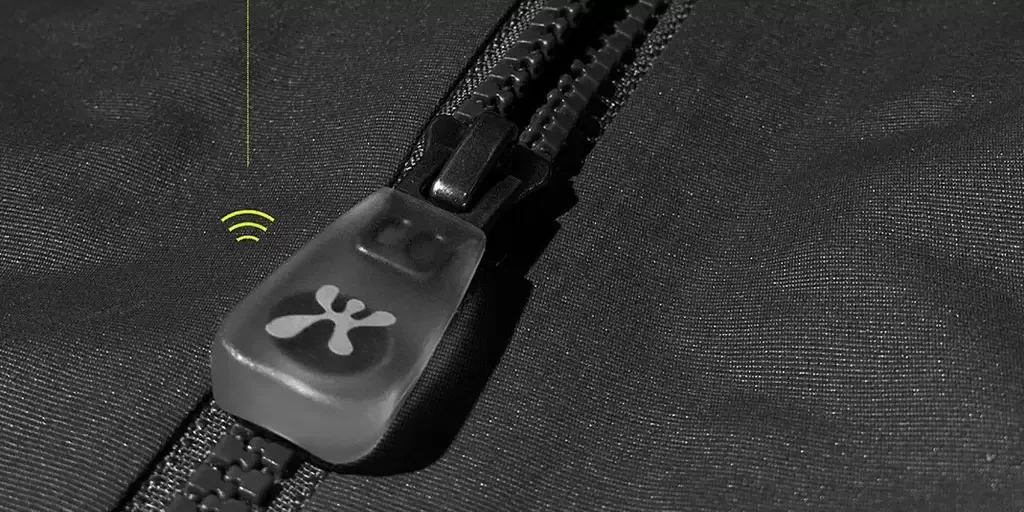 Close-up of a black zipper with a unique pull tab design, featuring a network signal icon on the fabric next to the zipper.