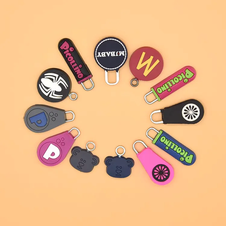 Circular arrangement of colorful custom zipper pullers in various shapes including bears, letters, and logos on an orange background.