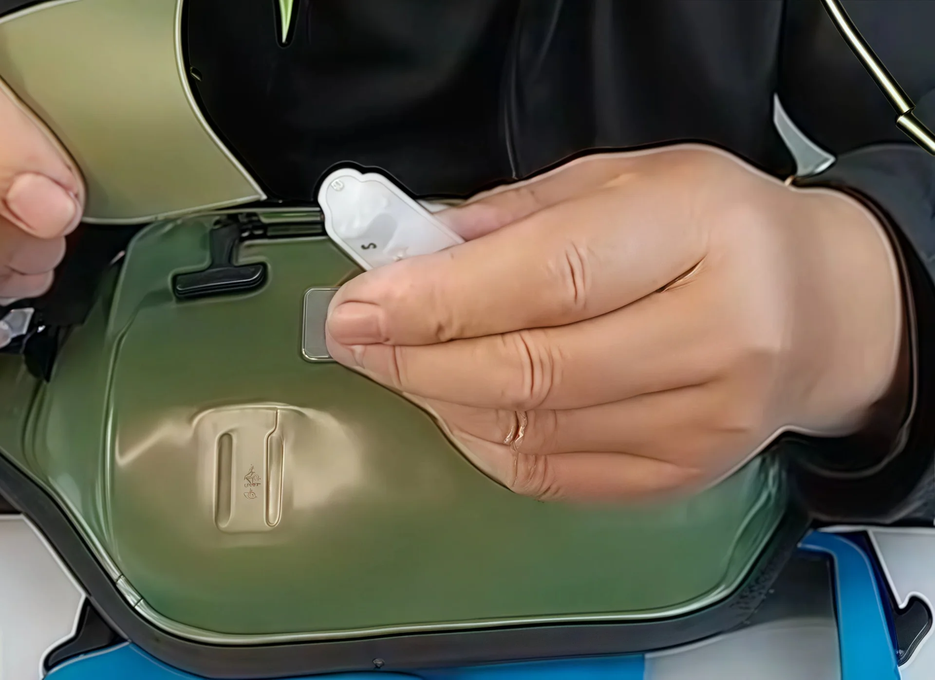 A hand closely examines a piece of bag material along with a label, focusing on details likely related to garment and bag accessory inspection.