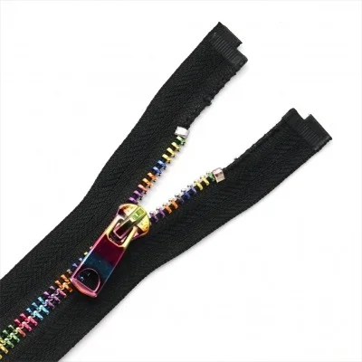 Open-ended black zipper with multicolored teeth and shiny rainbow slider on white background, showcasing vibrant design.