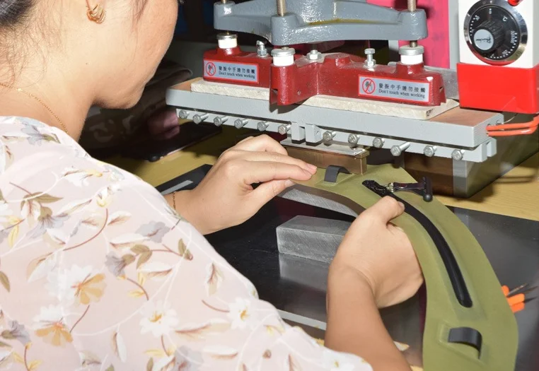 Woman carefully operates an industrial machine to handle garment accessories, demonstrating precision in manufacturing.