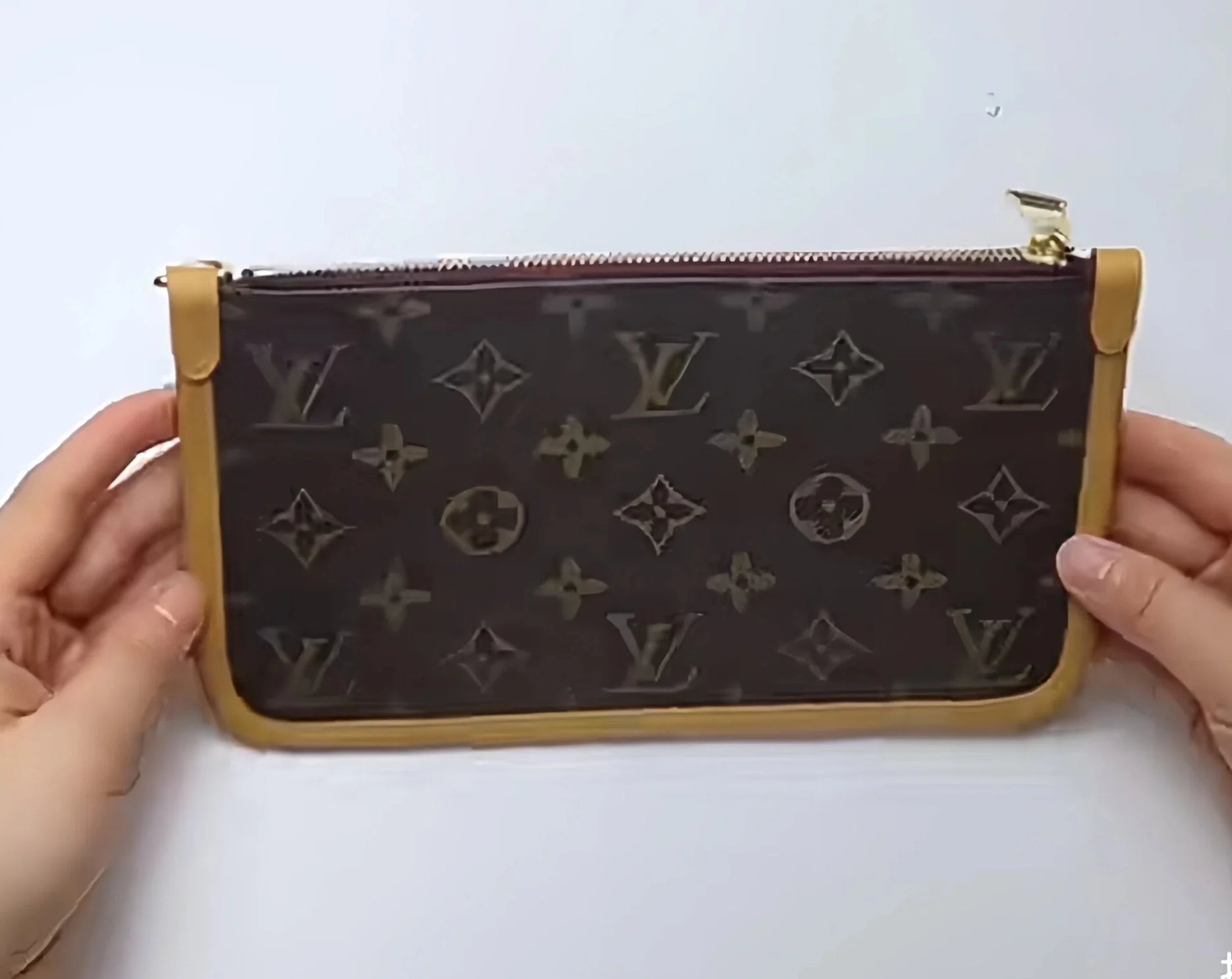 A brown leather pouch with a pattern, held by two hands against a plain background.